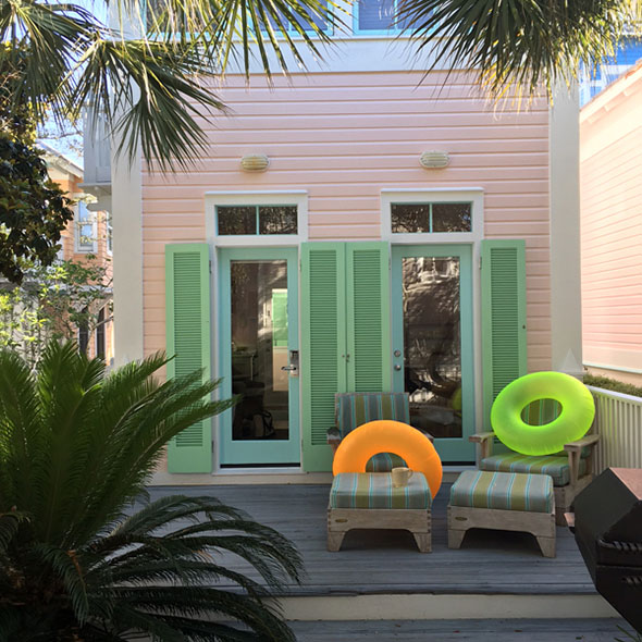 pink beach house with green shutters