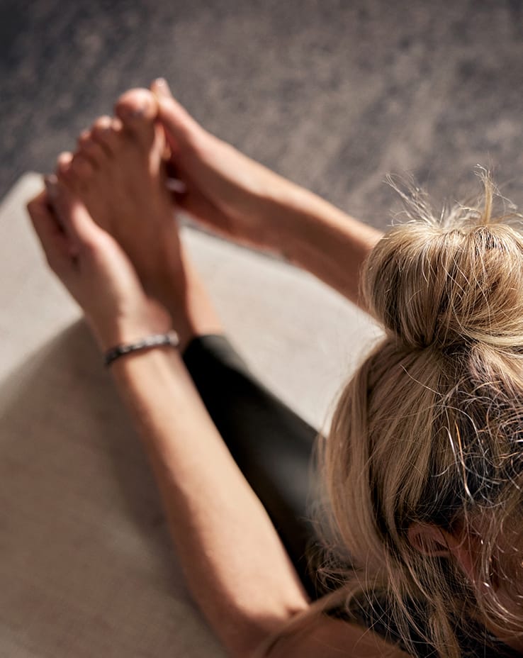 Woman stretching hands over foot