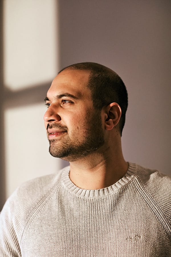 A man looking out of a sunny window and smiling