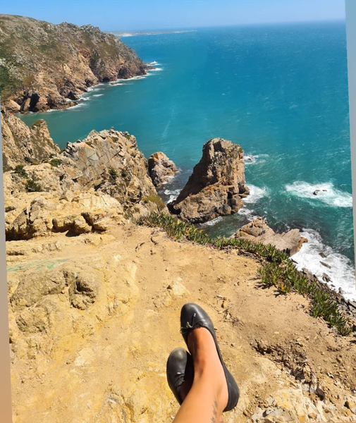 Feet on rock next to sea