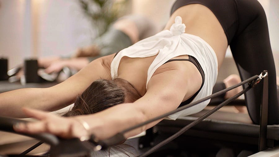 Woman stretching on Reformer bed