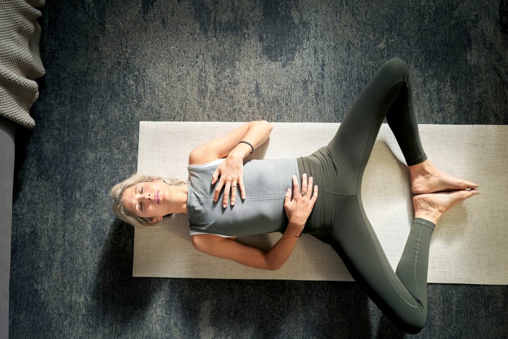 Woman relaxing at home on yoga mat